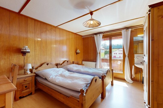 zimmer / schlafzimmer mit holzfußboden, kühler, holzwand, und natürliches licht