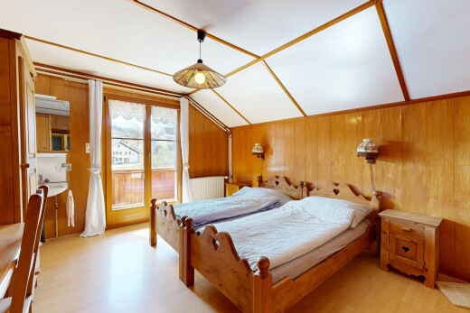 zimmer / schlafzimmer mit holzfußboden, holzwand, dachschräge, und natürliches licht