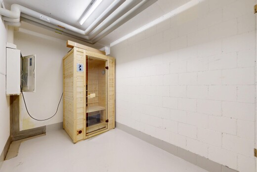 empty room with a relaxing sauna, concrete floors, and concrete block wall