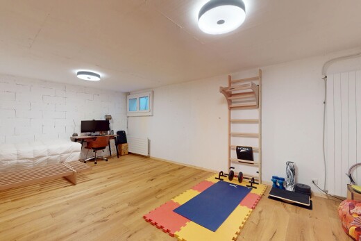 salon avec espace bureau, sol en finition bois, wood finish floor, inside property, et sous-sol