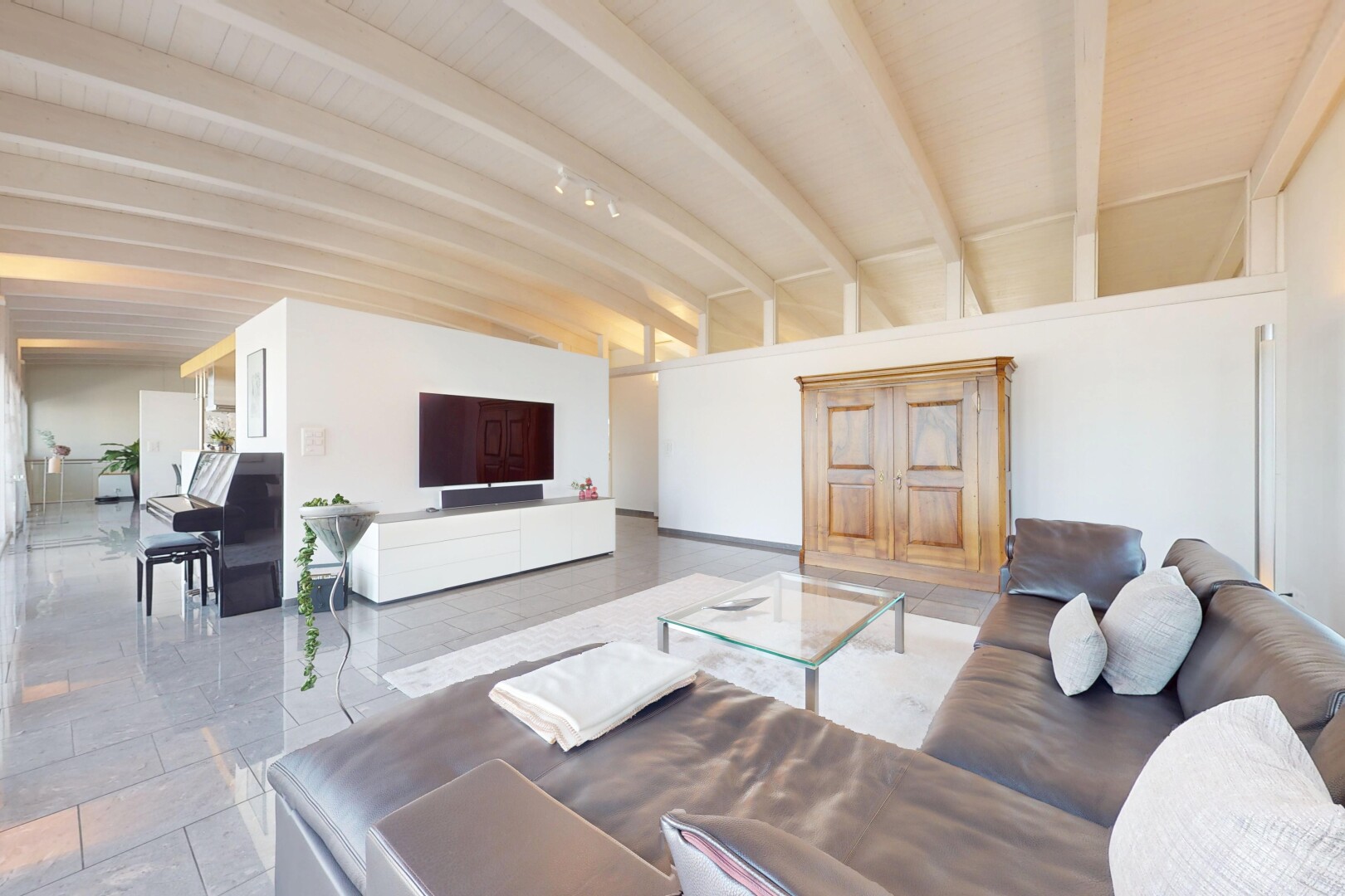 salon avec télévision, cloison sèche, drywall, inside property, et plafond à poutres