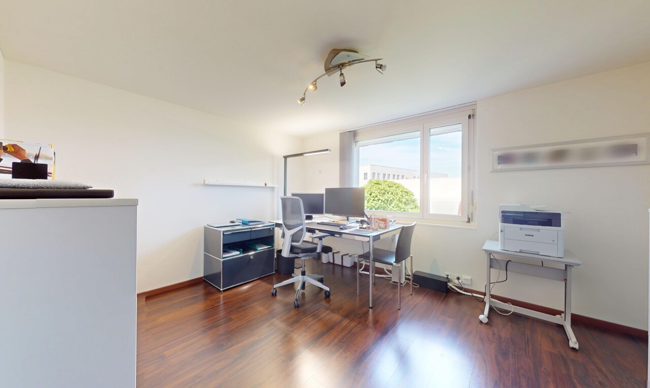 bureau avec télévision, lumière naturelle, natural light, sol en finition bois, et wood finish floor