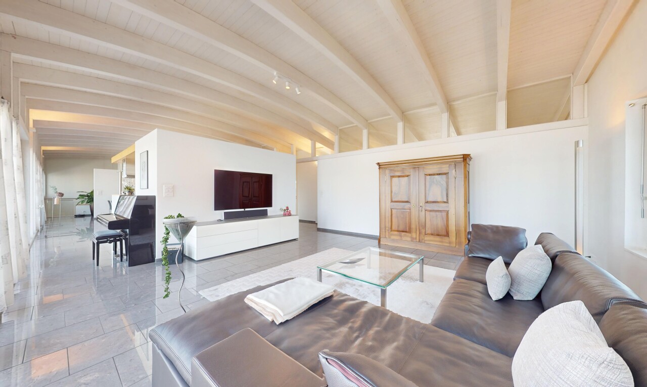 salon avec télévision, cloison sèche, drywall, inside property, et plafond à poutres