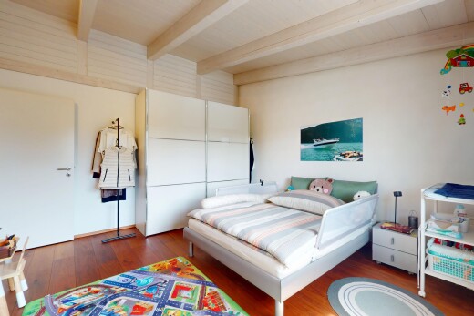 zimmer / schlafzimmer mit beamed ceiling, balkendecke, inside property, wood finish floor, und holzfußboden