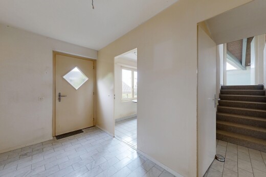 unfurnished room with stairs and baseboards