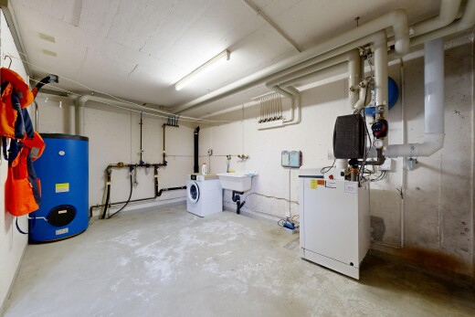 laundry area featuring concrete flooring and water heater