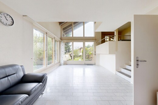 living room with healthy amount of natural light, light tile patterned floors, and a high ceiling