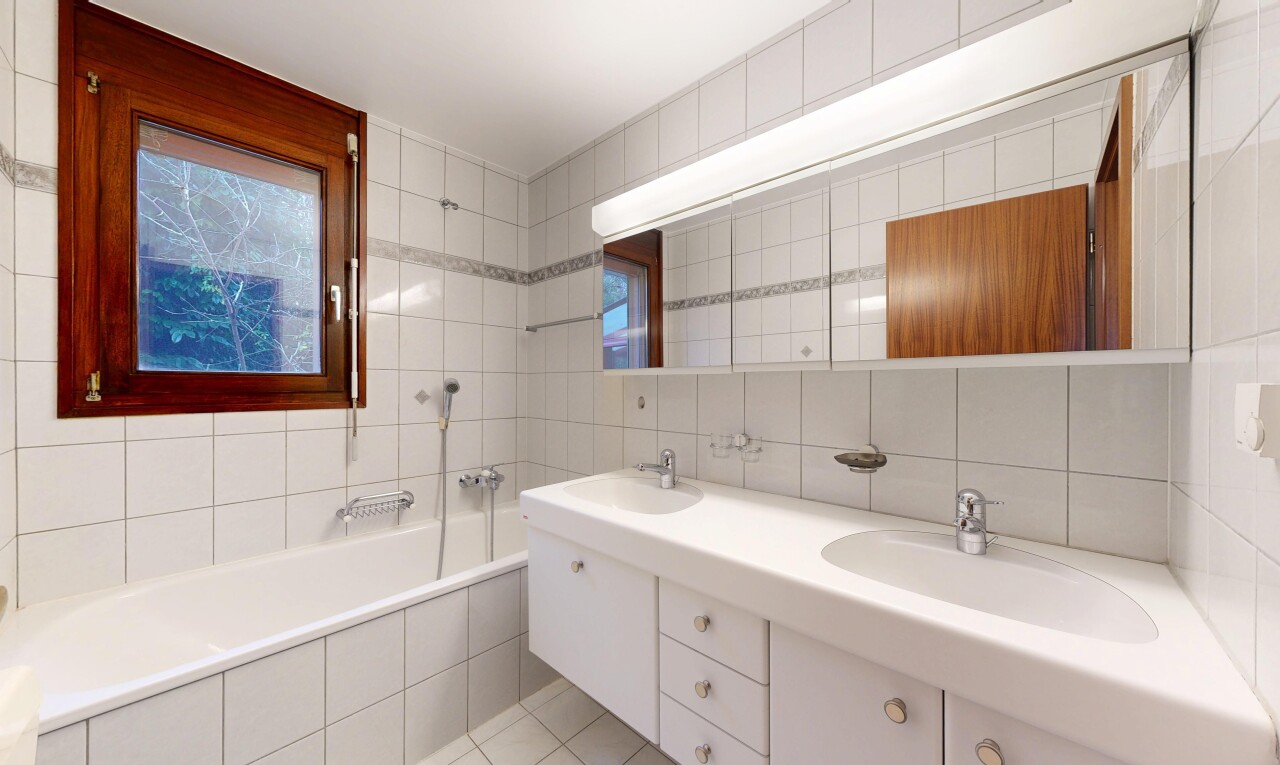 salle de bains avec salle de bain complète, double vasque, bain, mur en carrelage, et tile wall