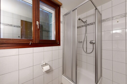 full bath featuring tile walls and a shower stall