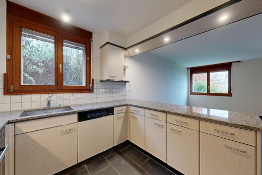 kitchen with backsplash, a peninsula, dark tile patterned flooring, dishwashing machine, and light stone countertops