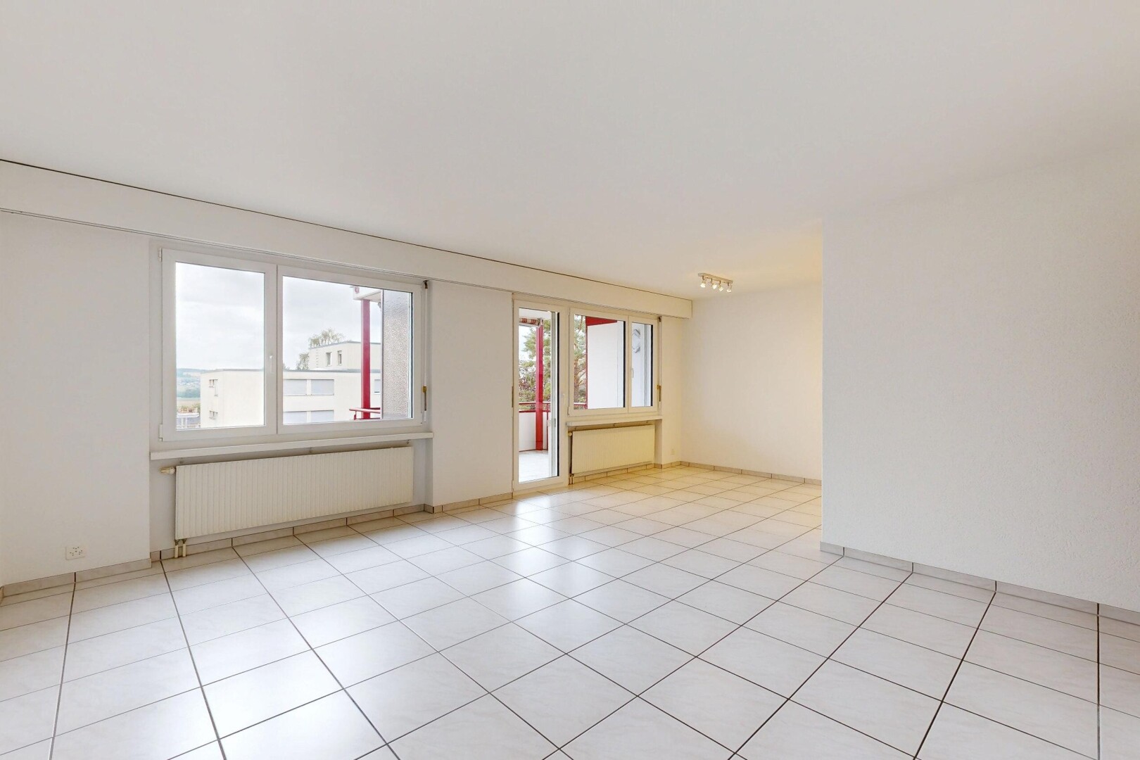 pièce vide avec éclairage sur rail, radiateur, drywall, cloison sèche, et light floor