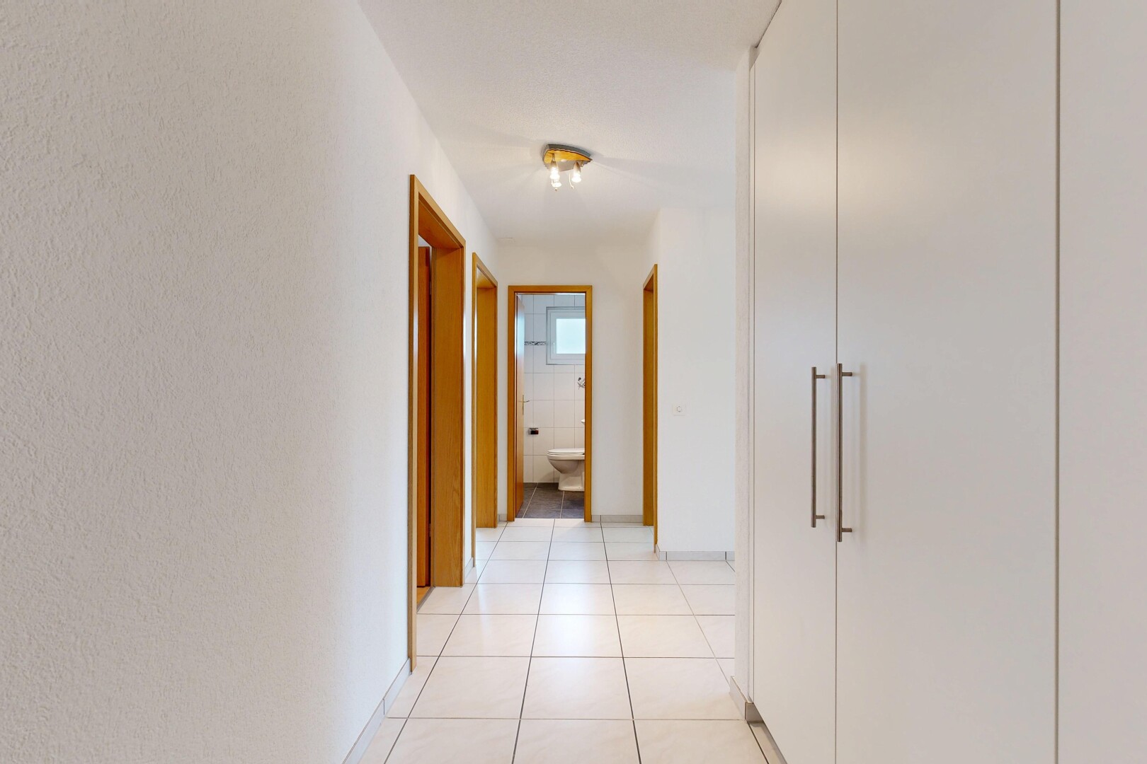 couloir avec light floor, sol en carrelage, tile floor, et inside property