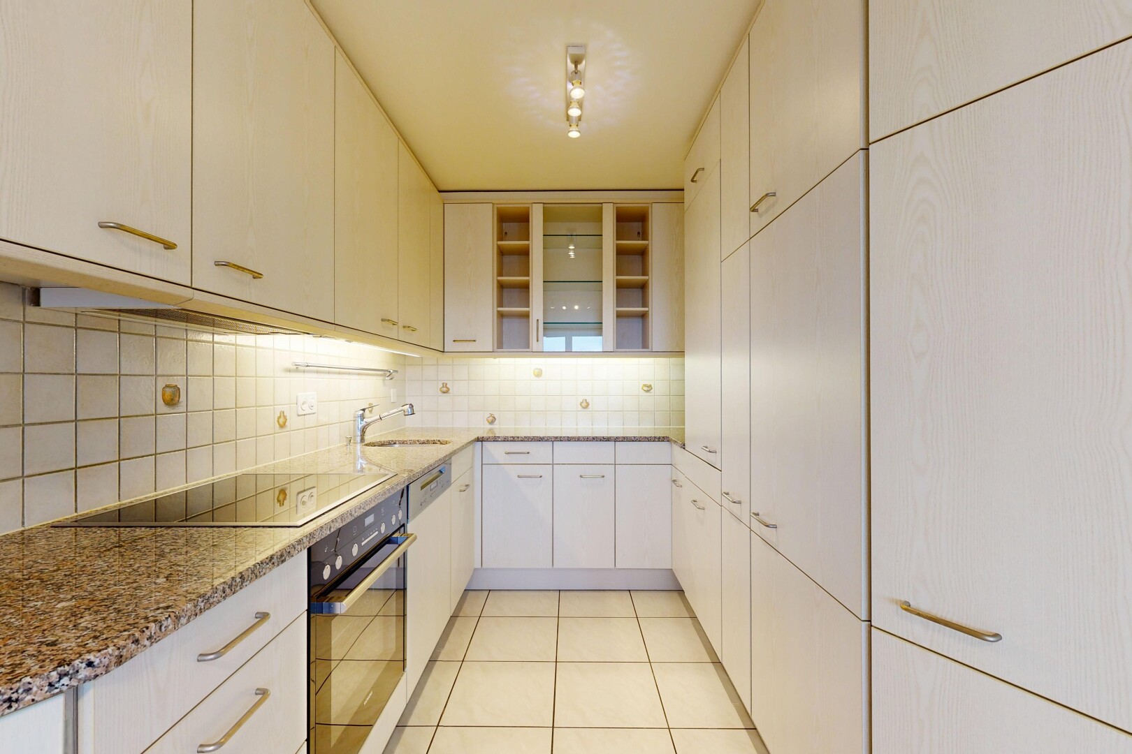 cuisine avec four, light floor, tile floor, sol en carrelage, et stone countertops