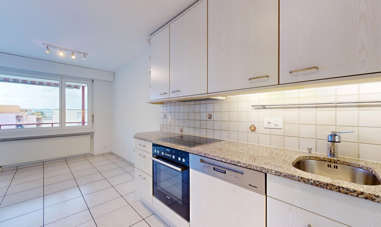 cuisine avec éclairage sur rail, light floor, lave-vaisselle, light countertops, et radiateur
