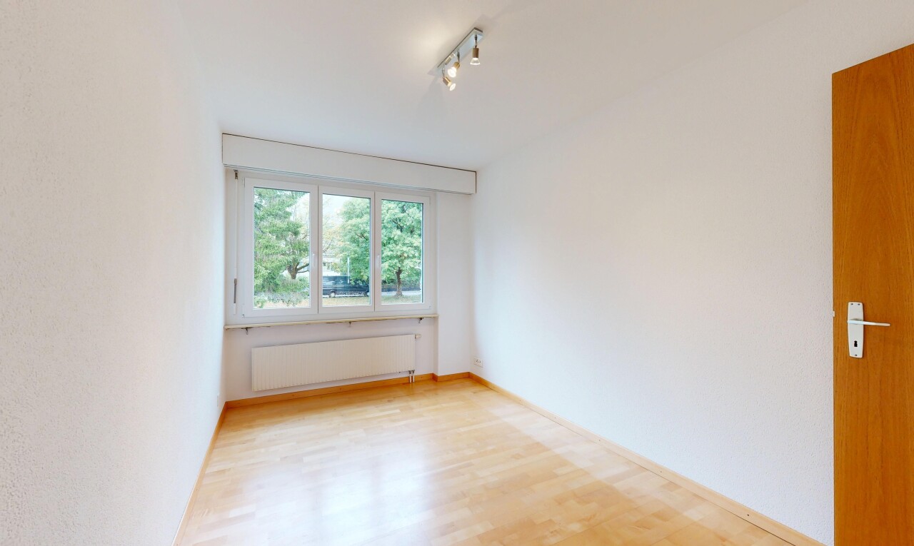 pièce vide avec éclairage sur rail, radiateur, wood finish floor, sol en finition bois, et baseboards wall