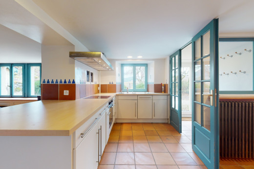 küche mit natürlichen licht, elektrischem kochfeld, weissen schränken, hellen arbeitsplatten und hellen fliesenböden