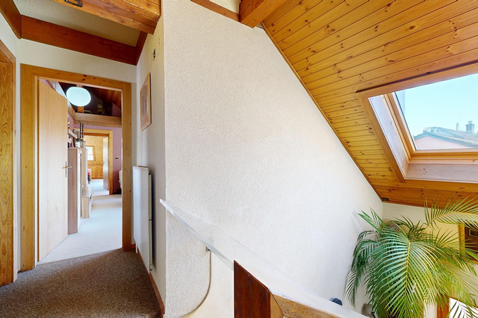 couloir avec inside property, moquette, carpet, plafond voûté, et vaulted ceiling