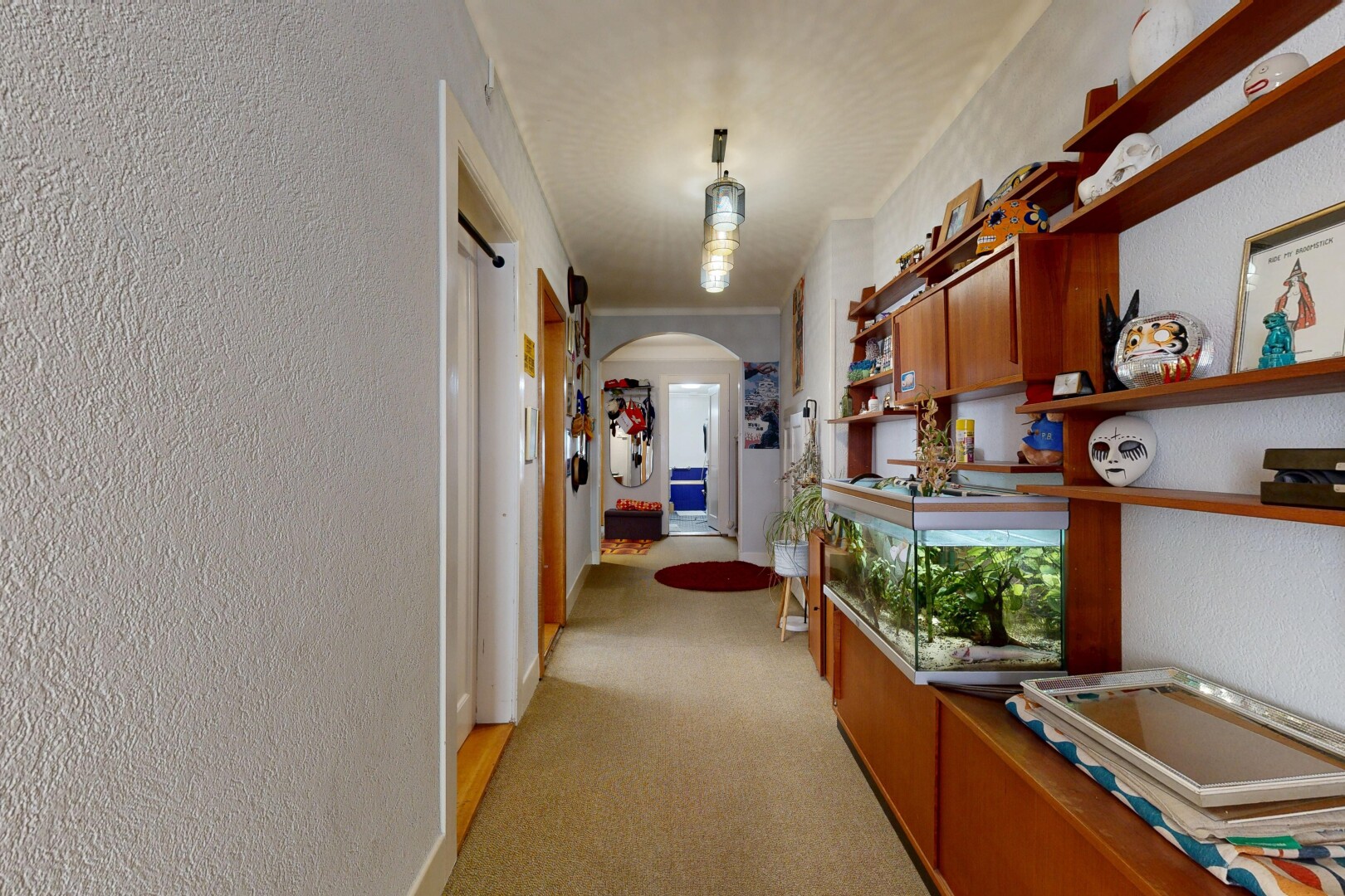 couloir avec passages en arc, moquette, carpet, light floor, et inside property