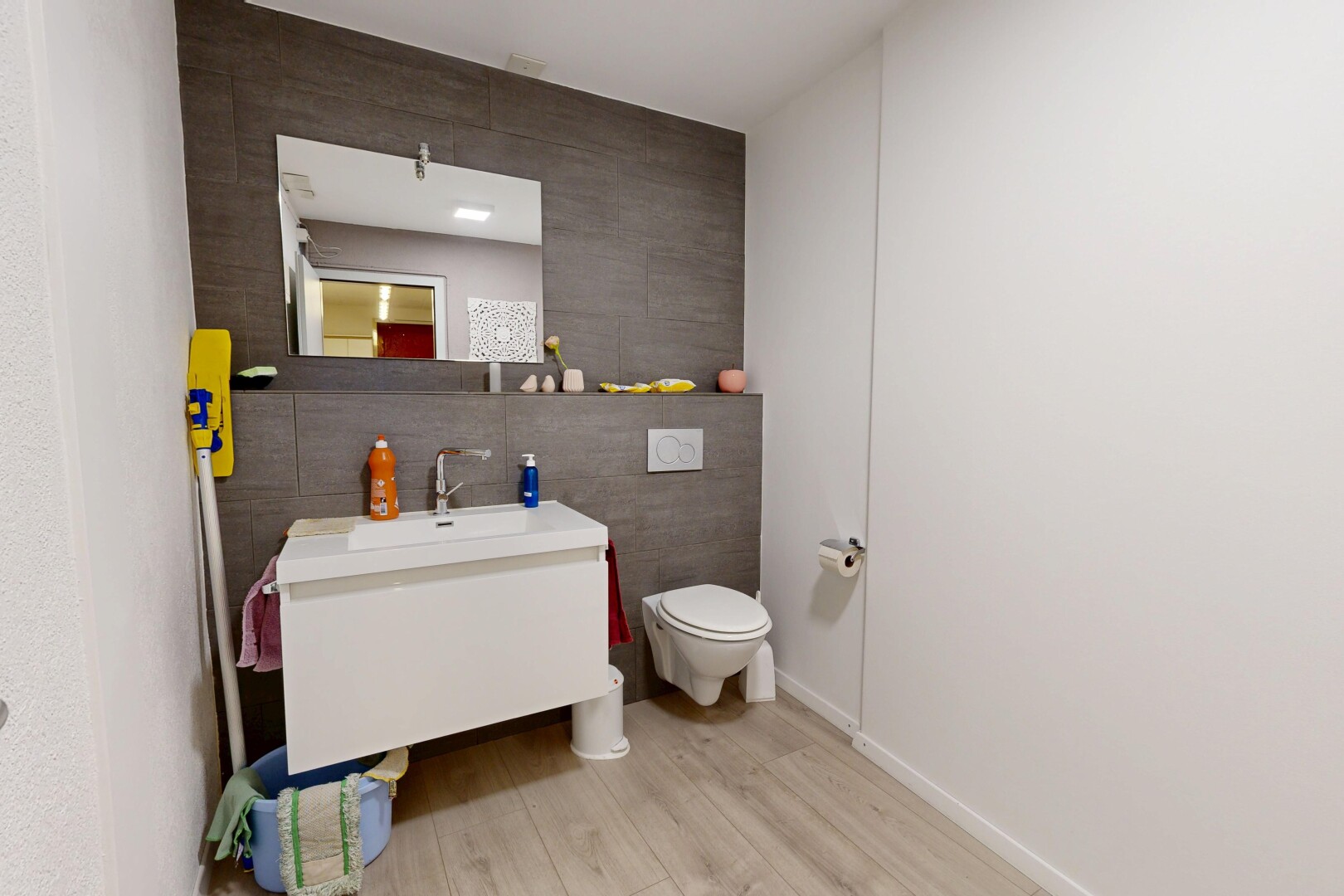 salle de bains avec tile wall, mur en carrelage, miroir, wood finish floor, et sol en finition bois