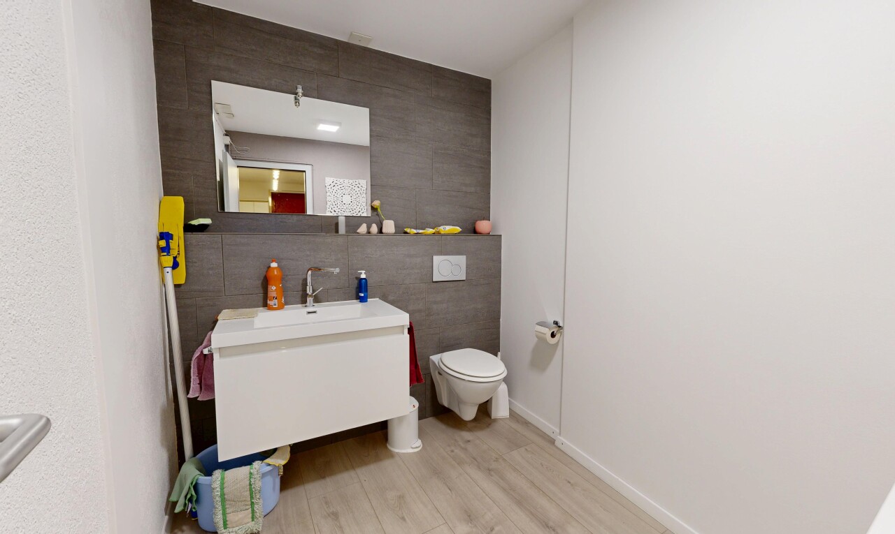 salle de bains avec tile wall, mur en carrelage, miroir, wood finish floor, et sol en finition bois