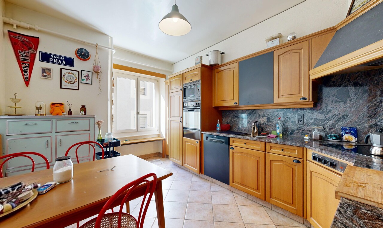 cuisine avec armoires en arc, arched cabinets, dark countertops, light floor, et inside property