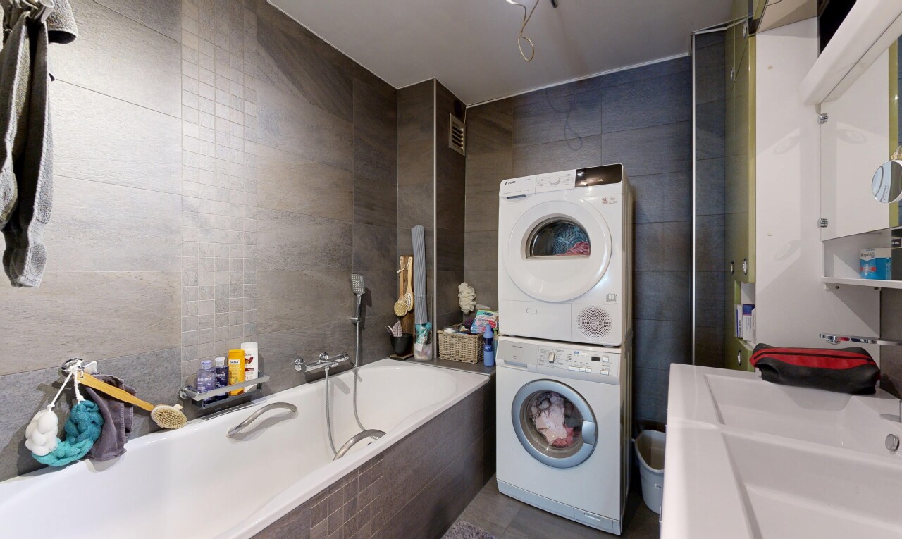 buanderie avec mur en carrelage, tile wall, buanderie, lave-linge et sèche-linge superposés, et inside property