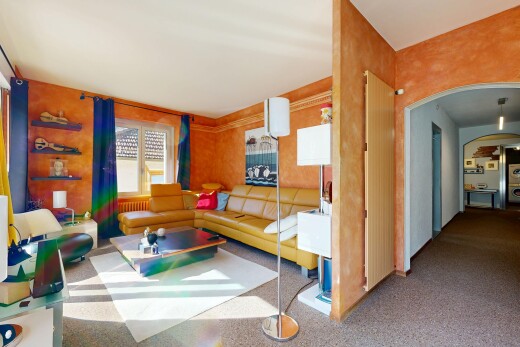salon avec passages en arc, moquette, carpet, inside property, et lumière naturelle