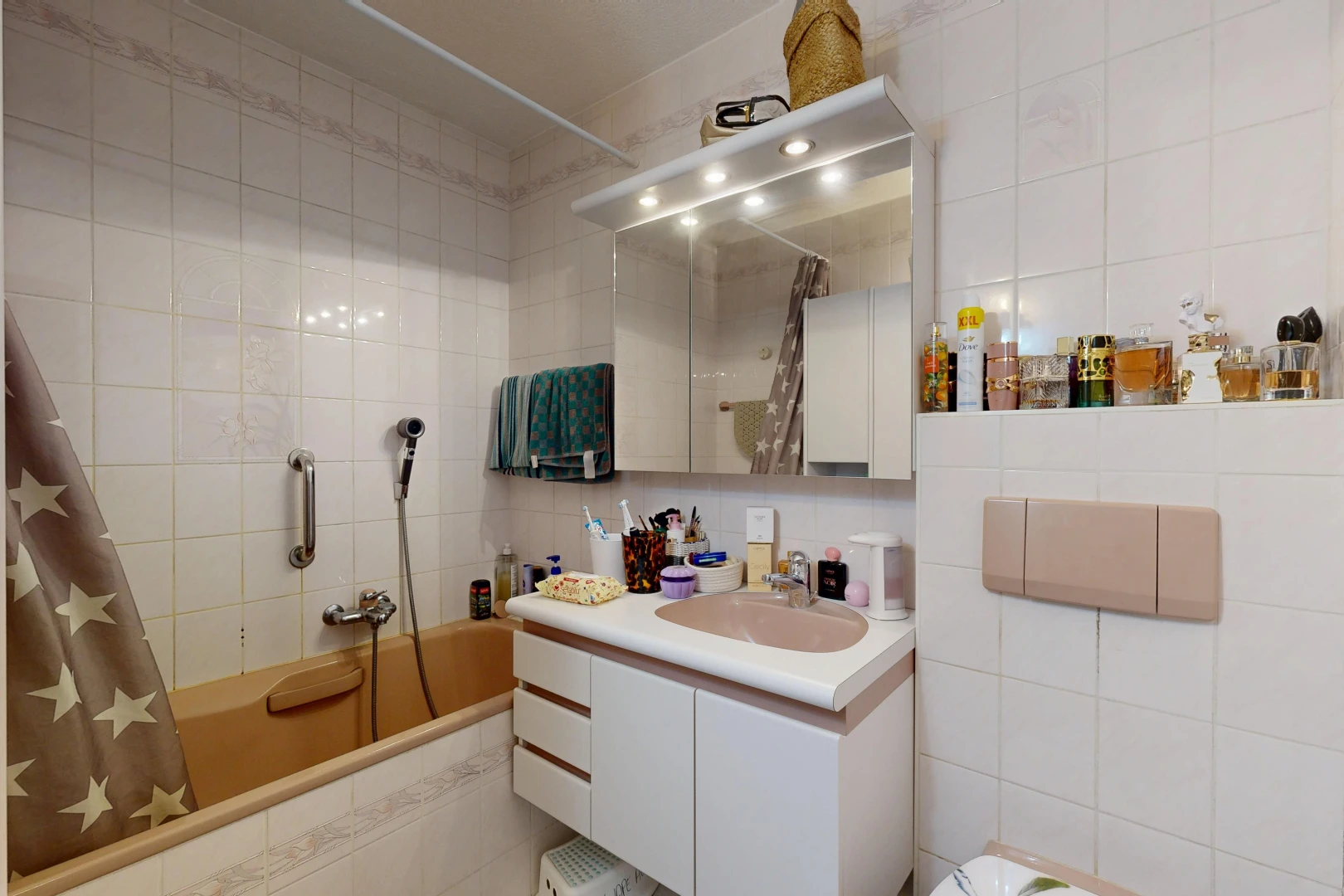 salle de bains avec salle de bain complète, mur en carrelage, tile wall, lavabo (ou coiffeuse selon le contexte), et miroir
