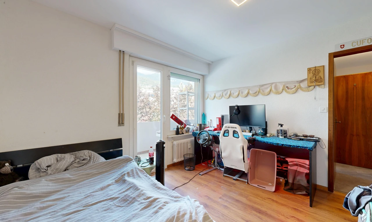 chambre avec drywall, cloison sèche, radiateur, télévision, et wood finish floor