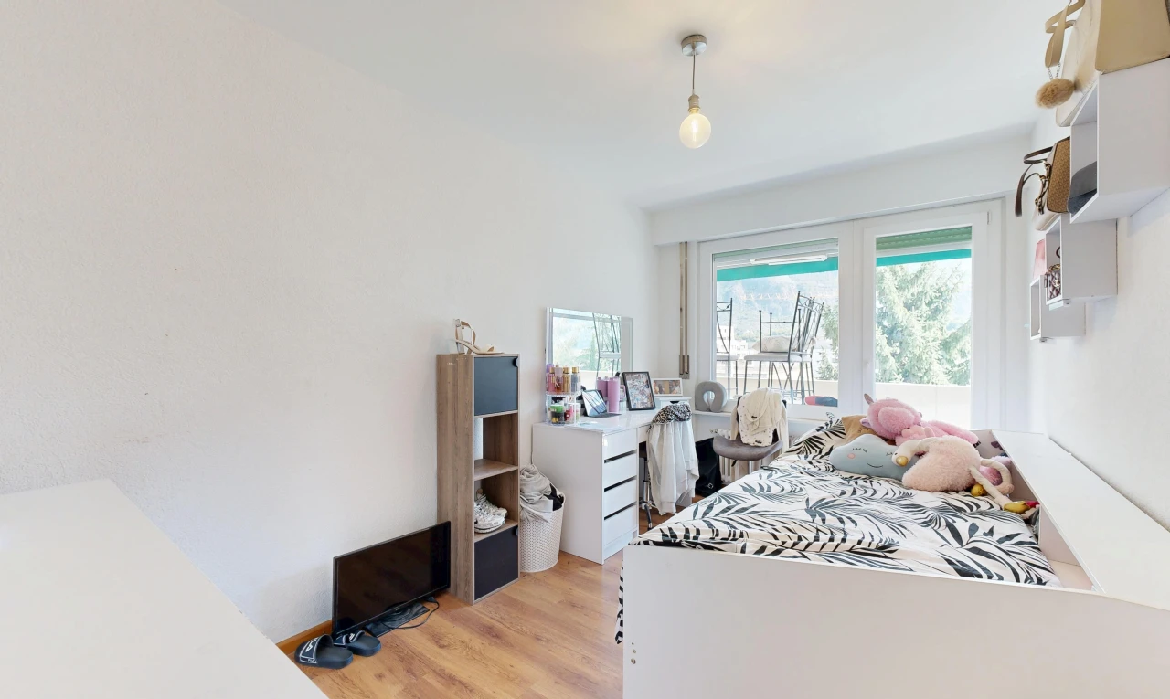 chambre avec éclairage suspendu, drywall, cloison sèche, wood finish floor, et sol en finition bois