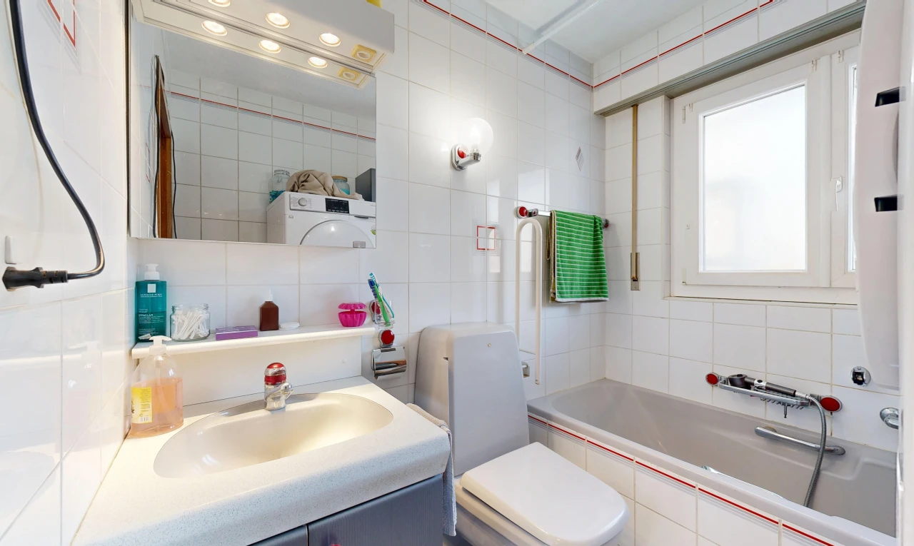 salle de bains avec salle de bain complète, miroir, évier, toilette, et tile wall