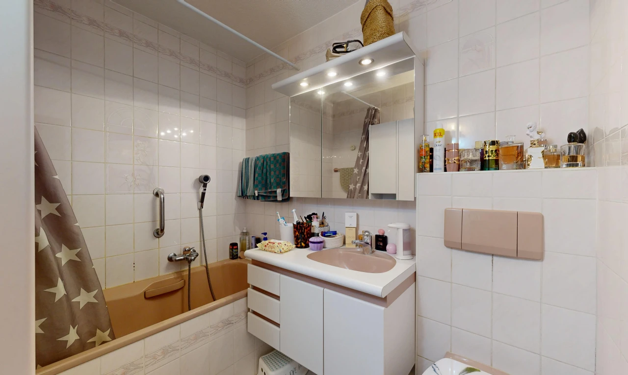 salle de bains avec salle de bain complète, mur en carrelage, tile wall, lavabo (ou coiffeuse selon le contexte), et miroir