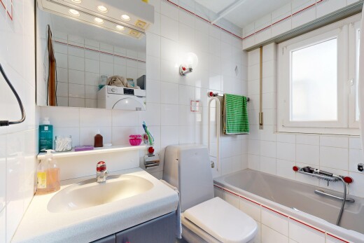 salle de bains avec salle de bain complète, miroir, évier, toilette, et tile wall