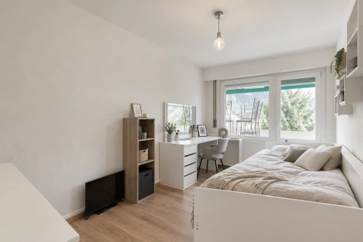 chambre avec éclairage suspendu, drywall, cloison sèche, wood finish floor, et sol en finition bois
