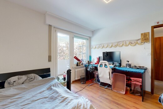 chambre avec drywall, cloison sèche, radiateur, télévision, et wood finish floor