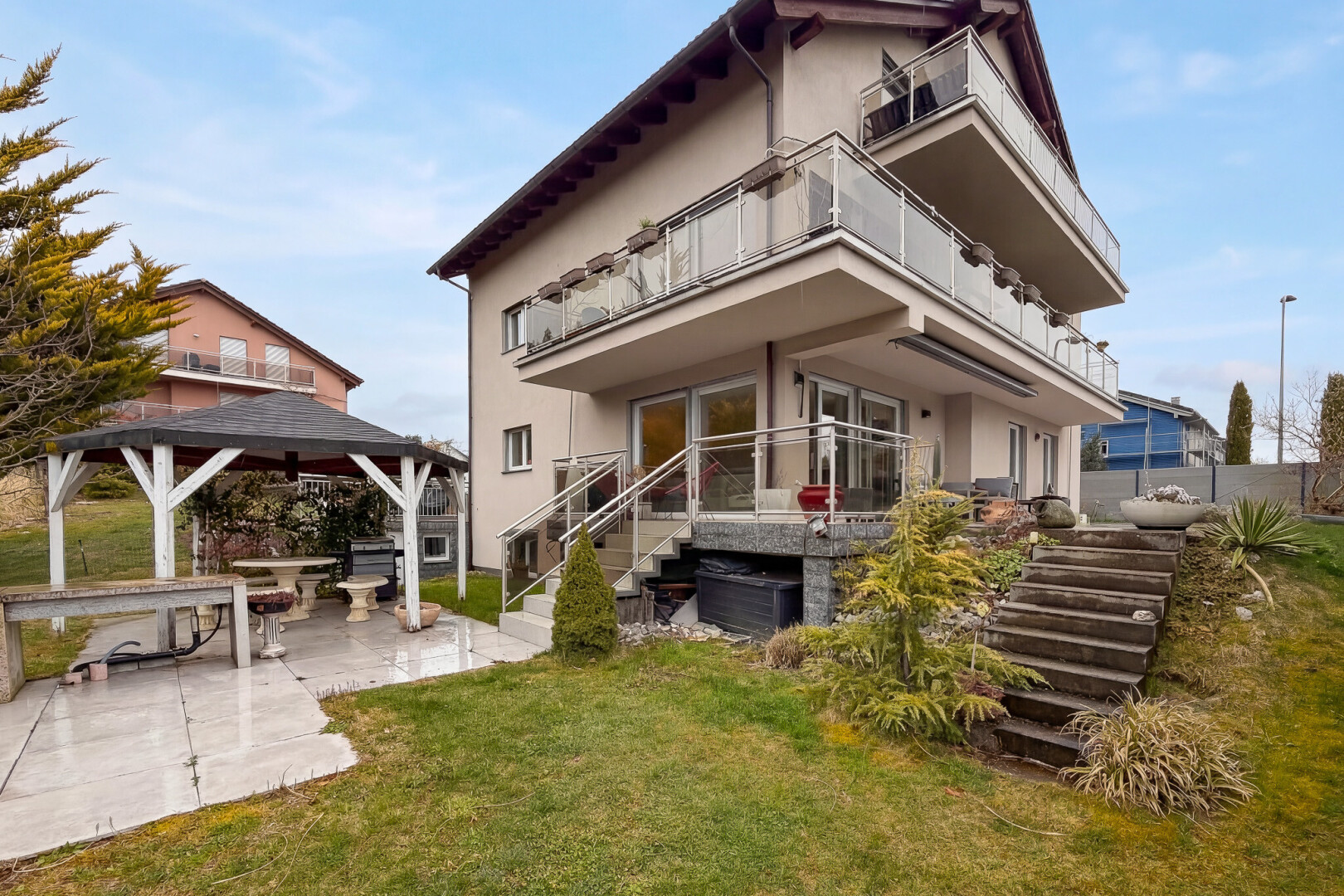 view of home featuring a balcony, a patio, stucco siding, a yard, and a gazebo