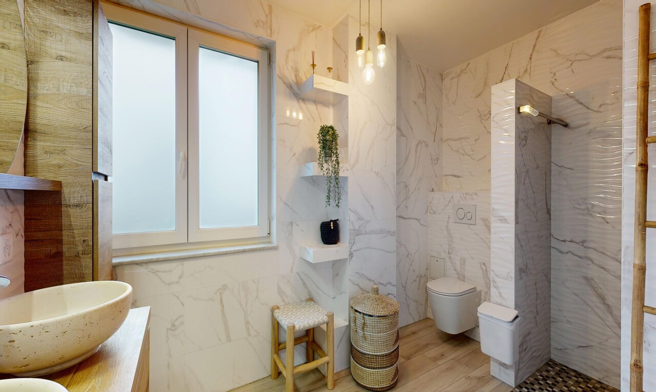 full bathroom with vanity, a marble finish shower, stone wall, and tile walls