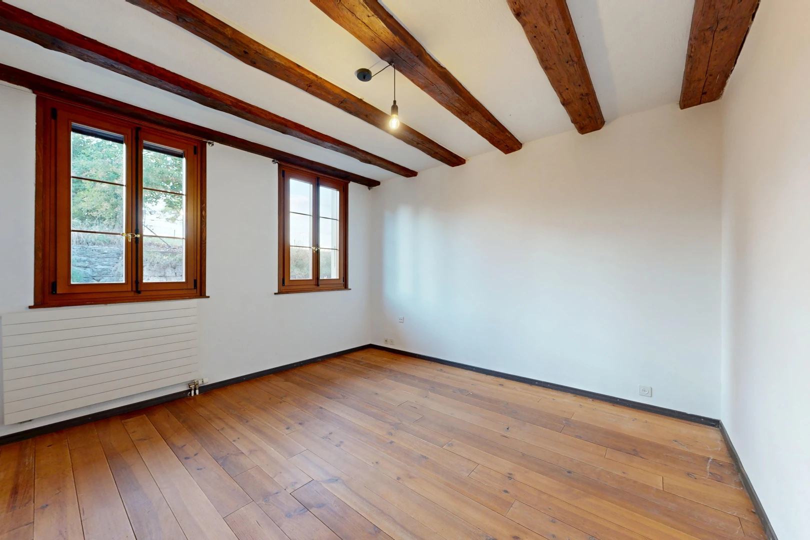 pièce vide avec radiateur, lumière naturelle, plafond à poutres, beamed ceiling, et cloison sèche