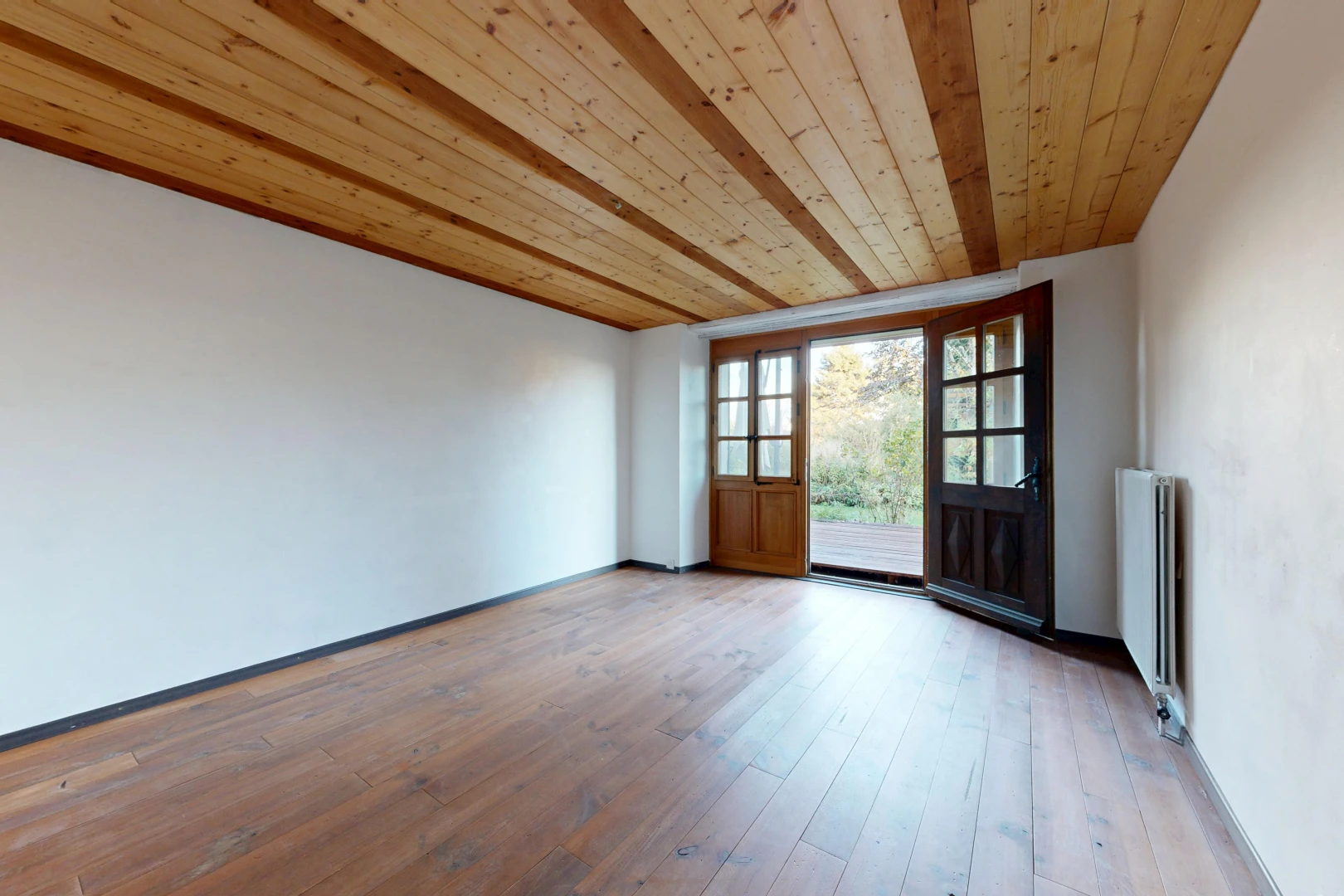 pièce vide avec plafond en bois, wood ceiling, accès à l'extérieur, high end ceiling, et radiateur