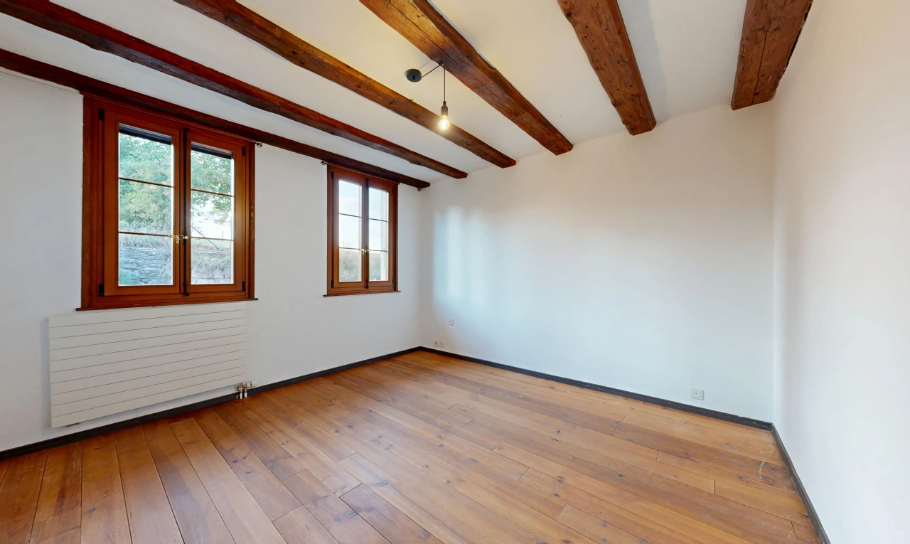 pièce vide avec radiateur, lumière naturelle, plafond à poutres, beamed ceiling, et cloison sèche