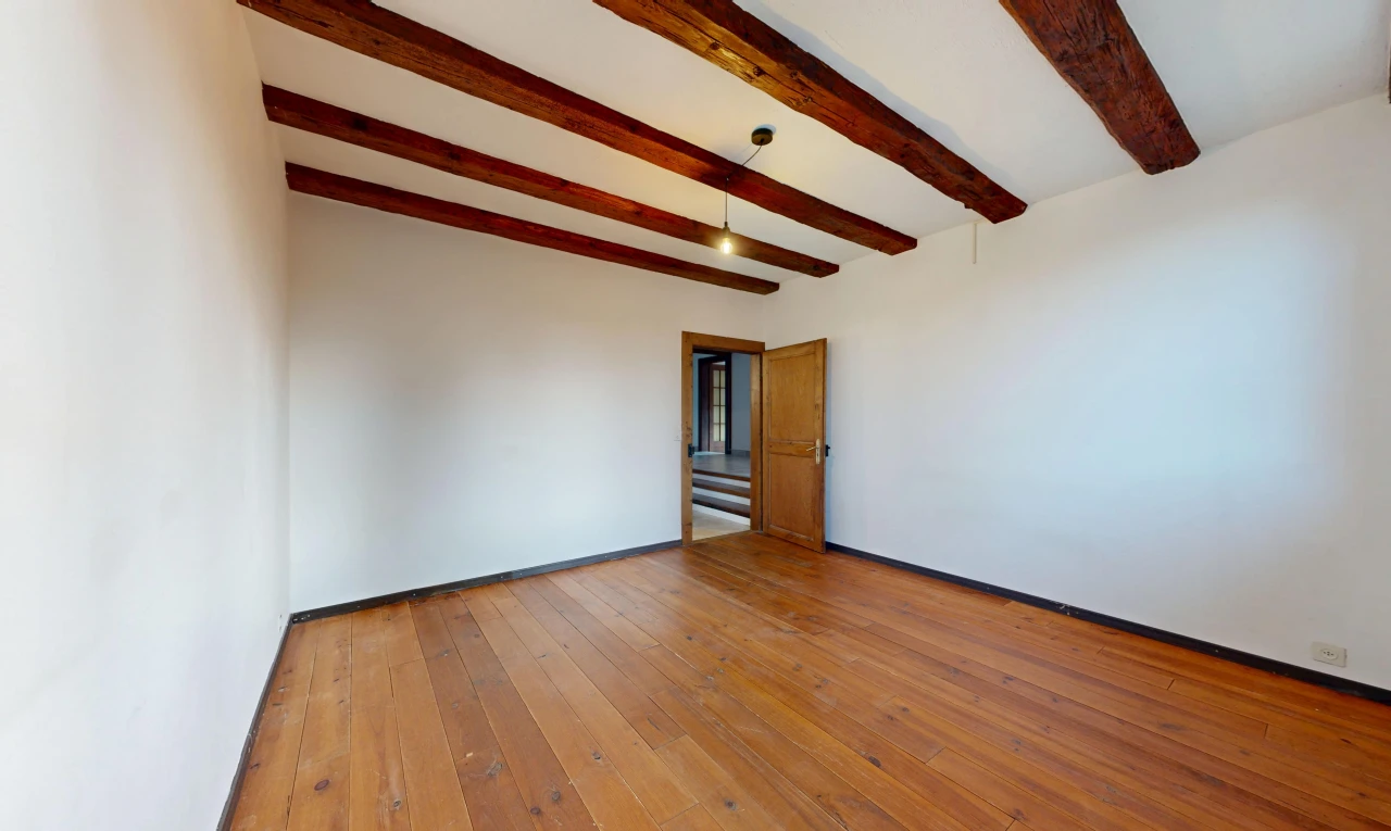 pièce vide avec plafond à poutres, beamed ceiling, hardwood floor, high end ceiling, et inside property