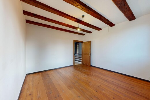 pièce vide avec plafond à poutres, beamed ceiling, hardwood floor, high end ceiling, et inside property