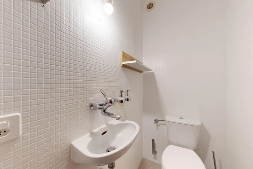 salle de bains avec évier, toilette, mur en carrelage, tile wall, et inside property