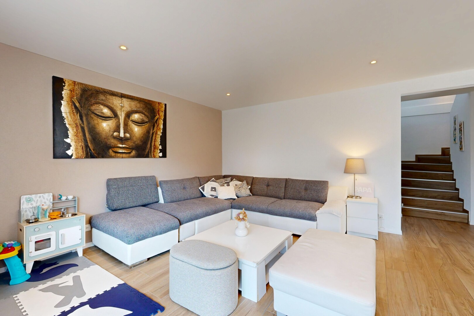 salon avec wood finish stairs, escaliers, drywall, cloison sèche, et wood finish floor