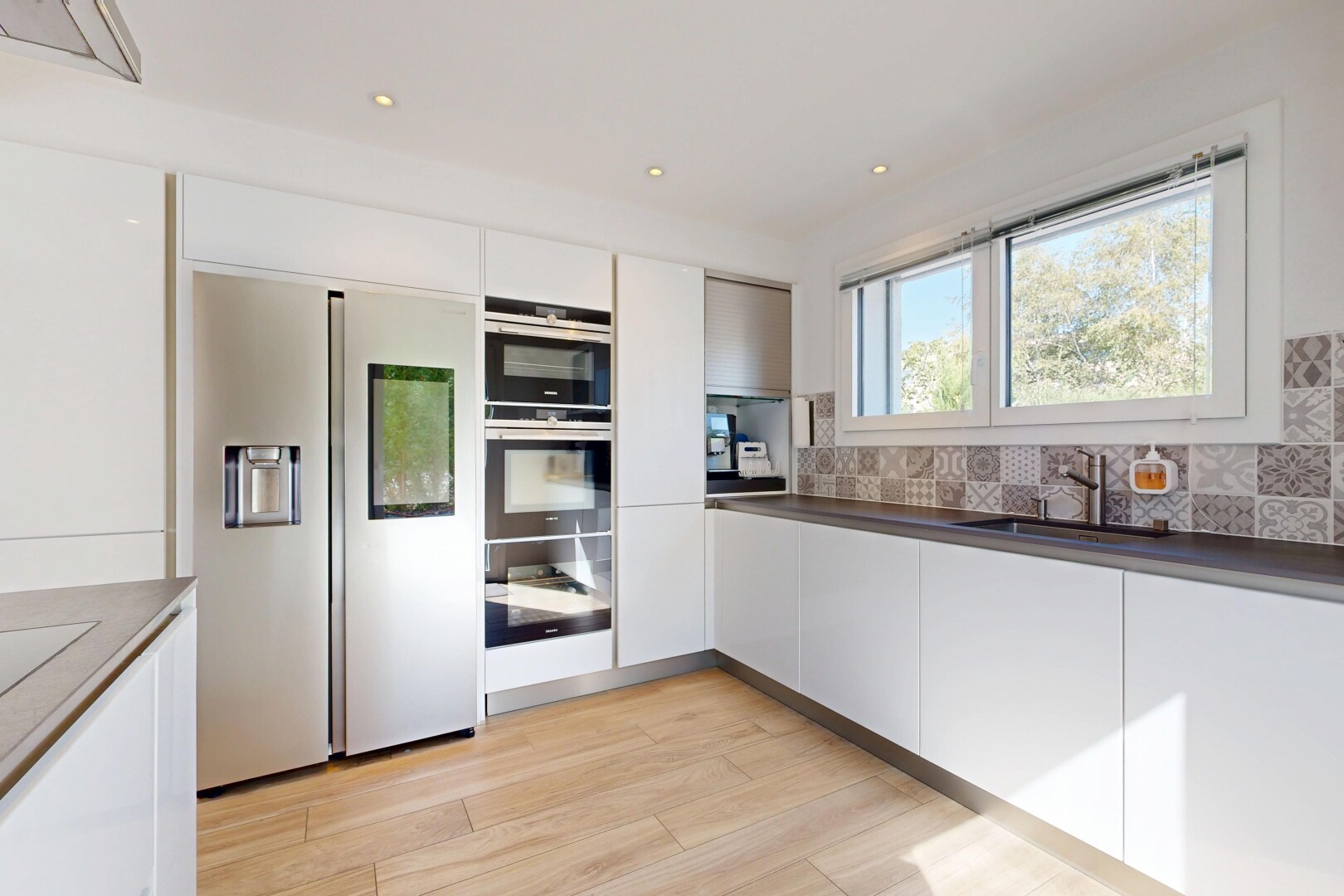 cuisine avec light floor, white cabinets, armoires blanches, backsplash, et dosseret