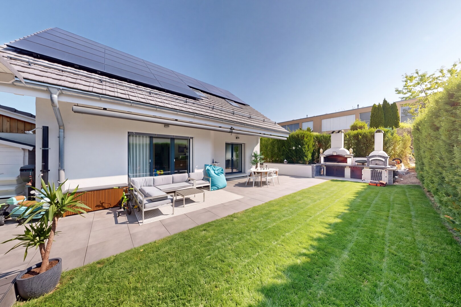 terrasse avec property visible, panneaux solaires, from property, pelouse, et day time