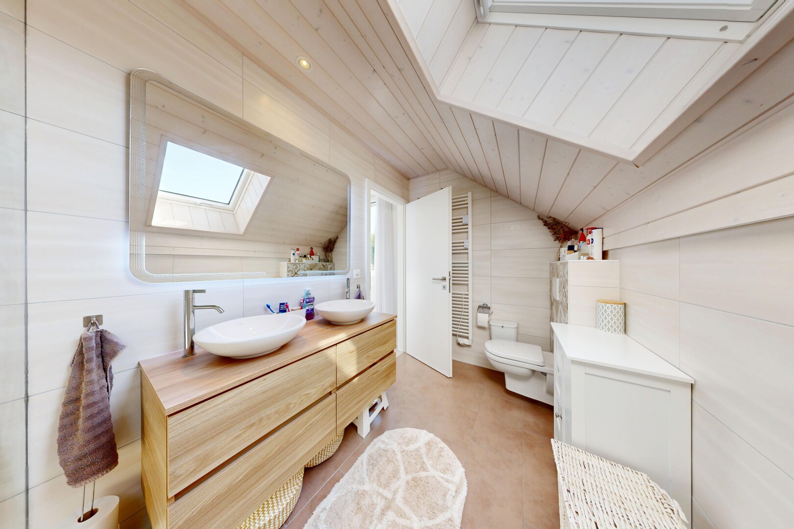 salle de bains avec puits de lumière, vaulted ceiling, plafond voûté, tile wall, et mur en carrelage