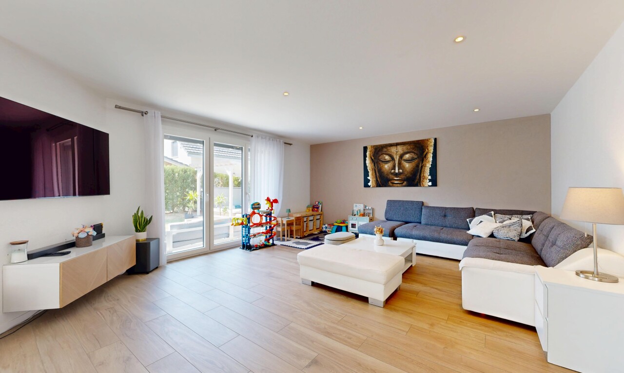 salon avec télévision, cloison sèche, drywall, sol en finition bois, et wood finish floor