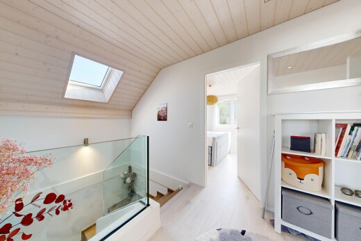 corridor with wood ceiling, an upstairs landing, vaulted ceiling with skylight, and healthy amount of natural light