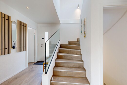 stairs with wood finished floors and recessed lighting